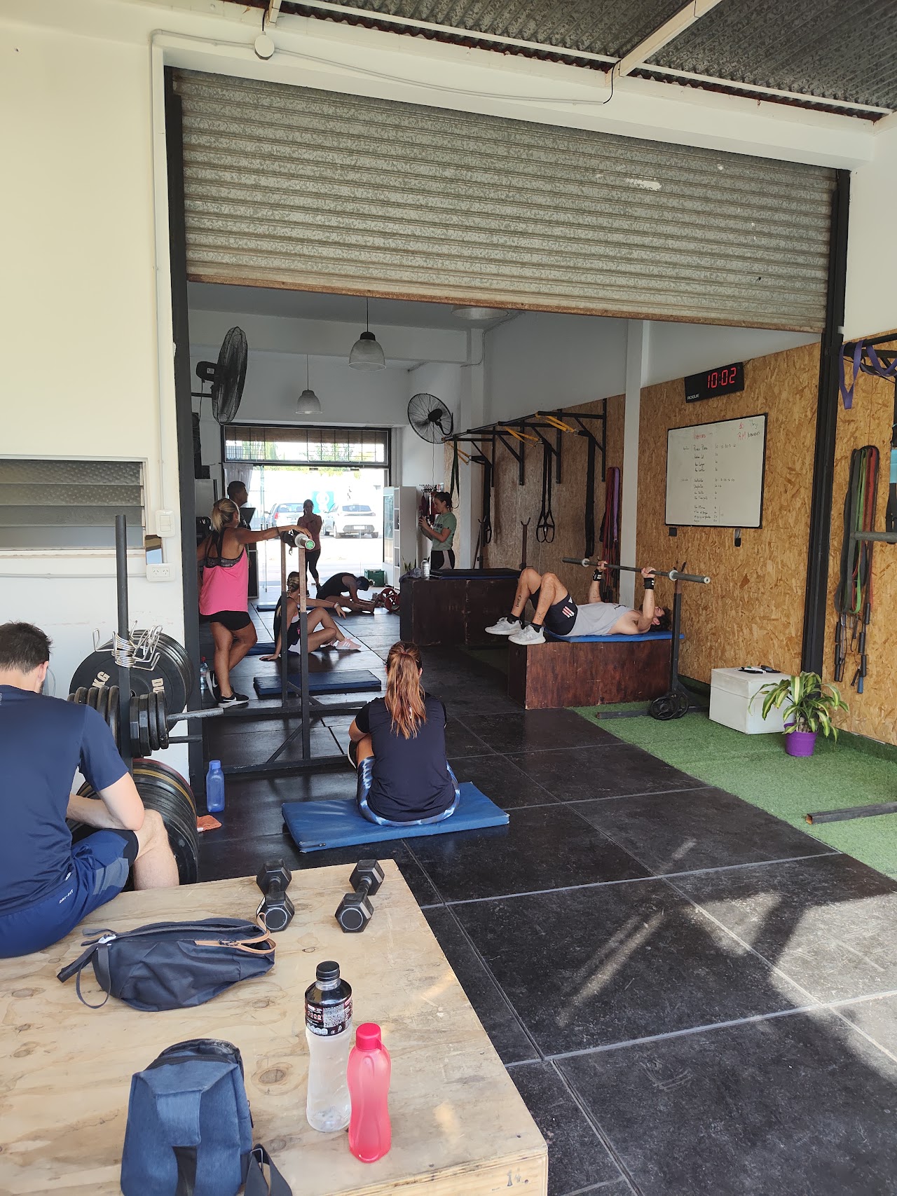 Atletas en clase de entrenamiento funcional en Dumping Fitness Castelar levantando pesas y kettlebells